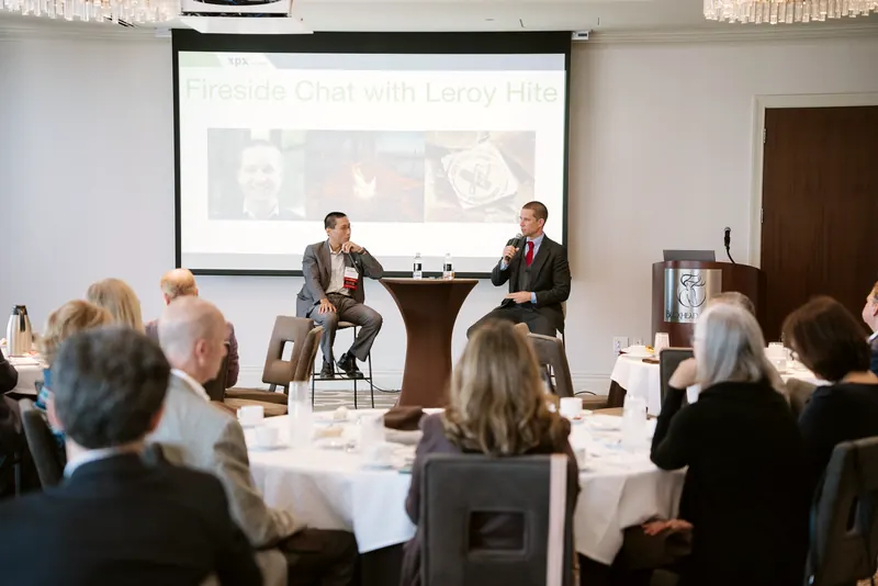 Leroy leading a fireside chat for a lunch audience
